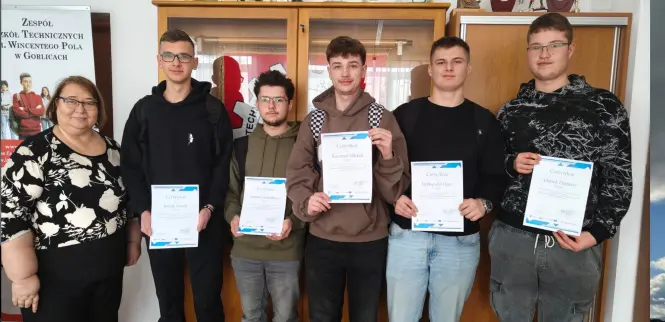 Grupa elektryków z dyplomami w towarzystwie Dyrekcji