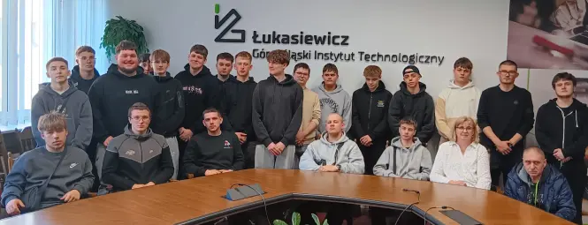 Grupa młodzieży wraz z opiekunem w sali Instytutu Spawalnictwa